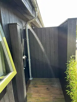 a fence with a shower with water coming out of it at Summer House With Wilderness Bath And Water Views in Vinderup