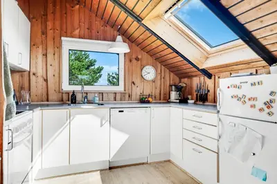 a kitchen with white cabinets and a window at Lovely Holiday Home With Wood-Burning Stove, Close To The North Sea In Klitmøller in Thisted