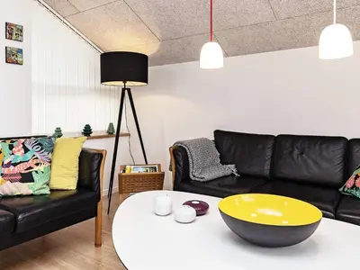 a living room with a black couch and a yellow bowl on a table at 8 person holiday home in Brovst-By Traum in Brovst