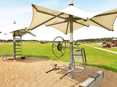 a playground with a white umbrella and a swing at 8 person holiday home in Brovst-By Traum in Brovst