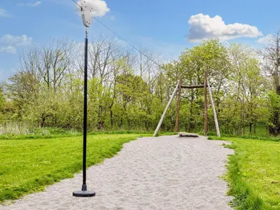a light pole and a swing set in a field at 12 person holiday home in Vestervig-By Traum in Vestervig
