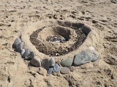 a circle of rocks in the sand on a beach at 8 person holiday home in Harboøre-By Traum in Harboør