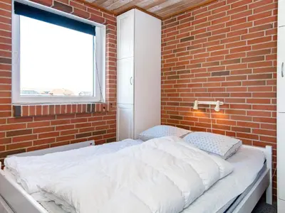 a bedroom with a bed in a brick wall at 8 person holiday home in Harboøre-By Traum in Harboør