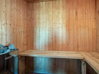 a sauna with a wooden wall and a trash can at 8 person holiday home in Harboøre-By Traum in Harboør