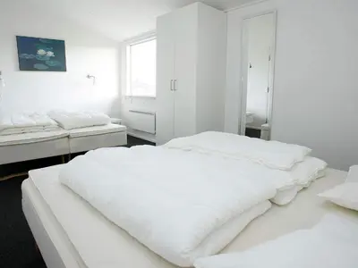 a white bedroom with two beds and a window at 16 person holiday home in Brovst-By Traum in Brovst