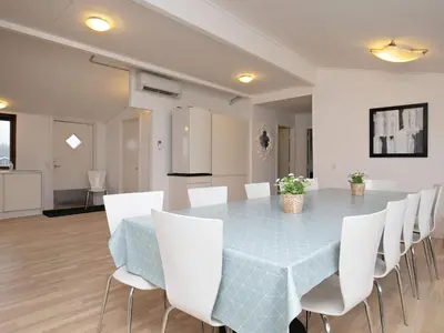 a dining room with a blue table and white chairs at 16 person holiday home in Brovst-By Traum in Brovst