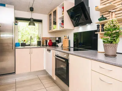 a kitchen with white cabinets and black appliances at 7 person holiday home in Hurup Thy-By Traum in Sønder Ydby