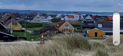 a view of a town with houses on a hill at Strandhuset in Agger