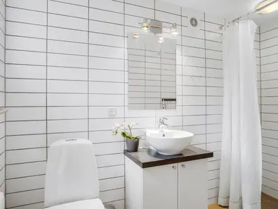 a white bathroom with a sink and a mirror at Holiday Home Ginne - 1km to the fjord by Interhome in Løgstør