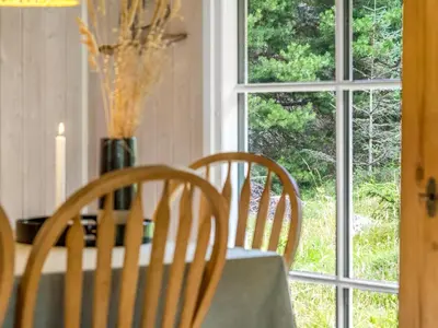 a table with two chairs and a vase with flowers at Holiday Home Nahuel - 1km from the sea by Interhome in Blokhus
