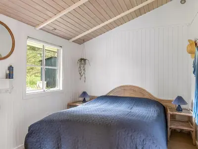 a bedroom with a blue bed and a window at Holiday Home Nahuel - 1km from the sea by Interhome in Blokhus