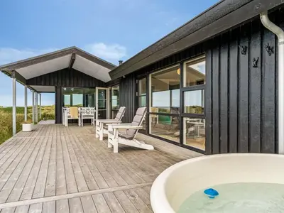 a house with a tub on a wooden deck at Holiday Home Jannus - 600m from the sea by Interhome in Saltum
