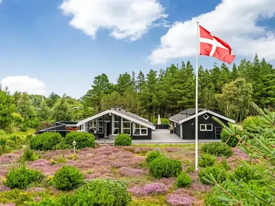 a house with a canadian flag in front of it at Holiday Home Eeske - 2-5km from the sea by Interhome in Blokhus