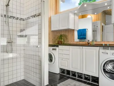 a bathroom with a washer and dryer and a shower at Holiday Home Eeske - 2-5km from the sea by Interhome in Blokhus