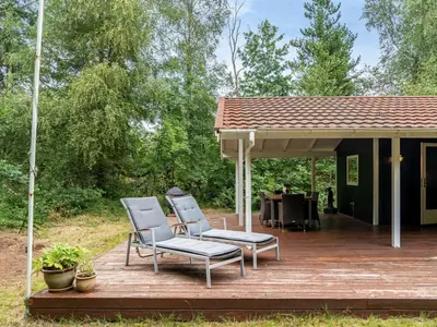 two chairs and a table on a wooden deck at Holiday Home Melisa - 3km from the sea by Interhome in Pandrup