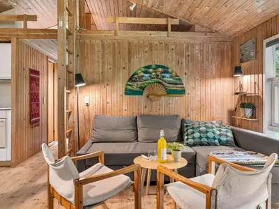 a living room with a couch and a table and chairs at Holiday Home Melisa - 3km from the sea by Interhome in Pandrup