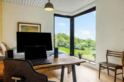 a laptop computer sitting on a wooden table in a living room at Summer House Close To Nature By The Limfjord in Nykøbing Mors