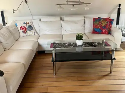 a white couch with a glass coffee table in a living room at Stor lejlighed i landlige omgivelser in Bækmarksbro