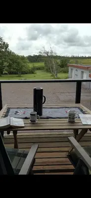 a wooden table with two coffee cups on a balcony at Stor lejlighed i landlige omgivelser in Bækmarksbro
