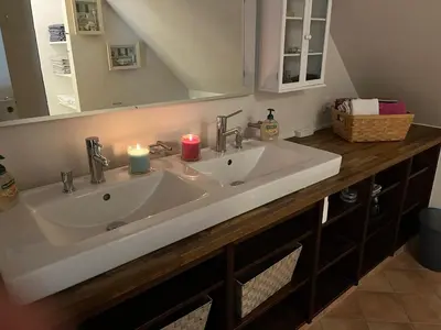 a bathroom with a sink with two candles on it at Stor lejlighed i landlige omgivelser in Bækmarksbro