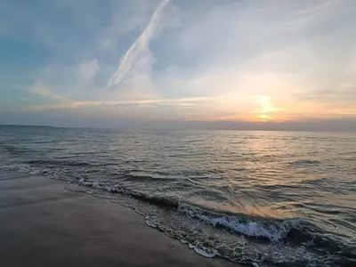 a sunset on the beach with the ocean at 6 person holiday home in Brovst-By Traum in Brovst