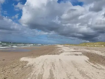 a sandy beach with footprints in the sand at 6 person holiday home in Brovst-By Traum in Brovst