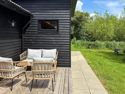 a patio with two wicker chairs and a table at 10 person holiday home in Vinderup-By Traum in Vinderup