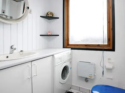 a bathroom with a washing machine and a sink at 6 person holiday home in Løkken-By Traum in Løkken