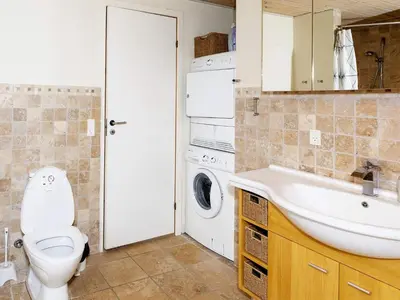 a bathroom with a toilet and a sink and a washing machine at 10 person holiday home in Brovst-By Traum in Brovst
