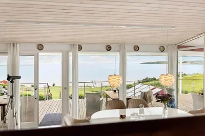 a dining room with a table and views of the ocean at G295-Lemvig-Syrenvej-95 in Lemvig