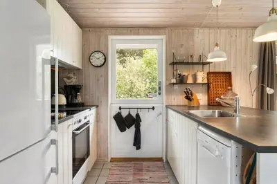 a kitchen with a sink and a clock on the wall at LK1123-Lokken-Piasvej-16 in Løkken
