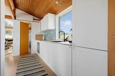 a kitchen with white cabinets and a window at LK2113-Lokken-Kettrup-Bjerge-vej-67 in Løkken