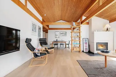 a living room with chairs and a television and a table at LK2113-Lokken-Kettrup-Bjerge-vej-67 in Løkken