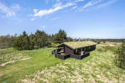 a house with a grass roof on top of a field at LK316-Lokken-Sarasvej-22 in Løkken