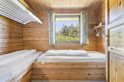 a room with two beds in a wooden room with a window at LK316-Lokken-Sarasvej-22 in Løkken