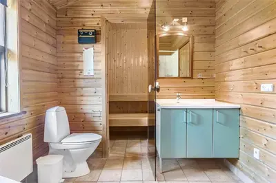 a wooden bathroom with a toilet and a sink at LK316-Lokken-Sarasvej-22 in Løkken