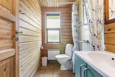 a bathroom with a toilet and a sink and a window at LK316-Lokken-Sarasvej-22 in Løkken