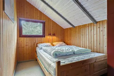 a bed in a wooden room with a window at LK473-Lokken-Kettrup-Bjerge-Vej-47 in Løkken