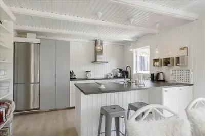 a white kitchen with a counter and a refrigerator at LK1706-Lokken-Redningsstien-20-A in Løkken