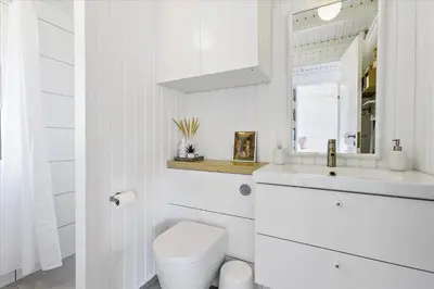 a white bathroom with a toilet and a sink at LK1706-Lokken-Redningsstien-20-A in Løkken