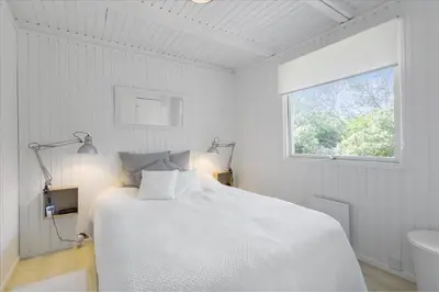 a white bedroom with a bed and a window at LK1706-Lokken-Redningsstien-20-A in Løkken
