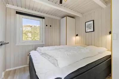 a bedroom with a large white bed with a window at LK1001-Lokken-Nellysvej-21 in Løkken