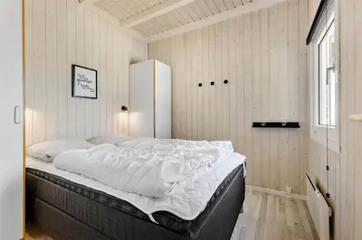 a bedroom with a large bed with white sheets at LK1001-Lokken-Nellysvej-21 in Løkken