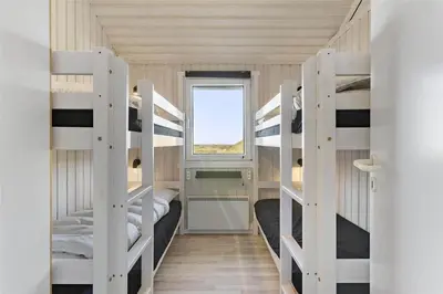 a room with four bunk beds and a window at LK1001-Lokken-Nellysvej-21 in Løkken