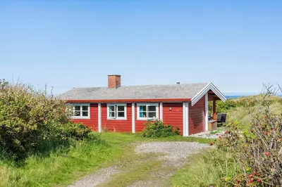 a red house on the side of a hill at LK1427-Lokken-Nannasvej-26 in Løkken