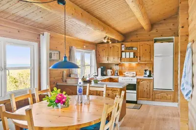 a kitchen with a wooden ceiling and a table with chairs at LK1427-Lokken-Nannasvej-26 in Løkken