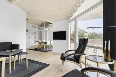 a living room with a table and chairs and a tv at LK1423-Lokken-Rikkesvej-4 in Løkken