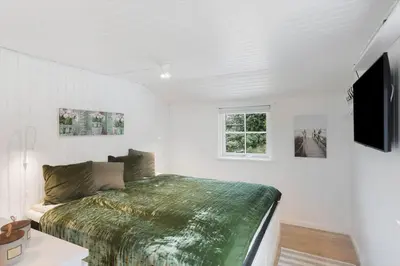 a bedroom with a bed and a television in it at LK2087-Lokken-Karinavej-54 in Løkken