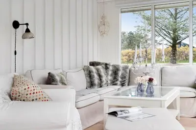 a living room with white furniture and a window at LK2087-Lokken-Karinavej-54 in Løkken
