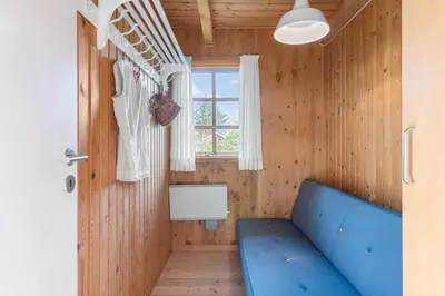 a room with a blue couch and a window at LK2098-Lokken-Magdalenevej-51 in Løkken